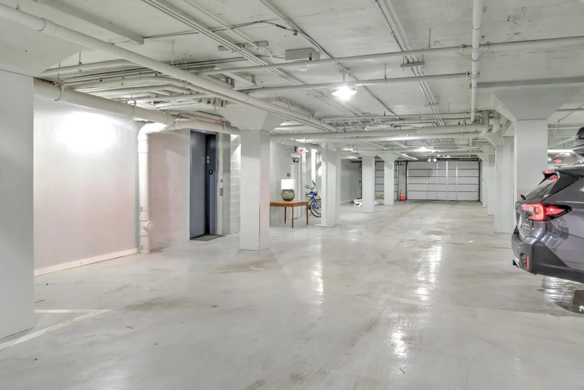 This image features an elevator and bicycle area within a practical, neutral-toned space that hints at convenient vehicle storage and easy access. The environment is functional and suggests the presence of garage parking, aligning closely with the section's emphasis on seamless arrival and urban mobility.